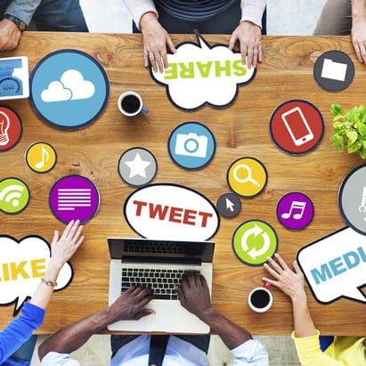 Social media strategy is shown as varied icons at a business table